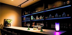A bar area with shelves of bottles and glasses, a bar counter, and a plant. - Luxuary Villa Maeda I (Kunigami-gun)
