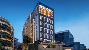 A modern hotel with a prominent entrance, multiple floors, and a clear sky. - IntercityHotel Gaungzhou Financial City (Guangzhou)