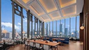 A modern dining area with large windows, high ceilings, and city views. - IntercityHotel Gaungzhou Financial City (Guangzhou)