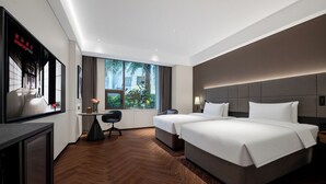 A modern hotel room with a large bed, a desk, a chair, and a television. - IntercityHotel Gaungzhou Financial City (Guangzhou)
