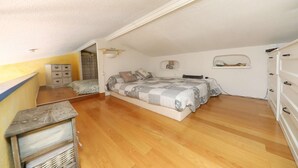 A bedroom with a bed, dresser, and a small table. - A pleasant, air-conditioned studio with Wi-Fi in the heart of Port Grimaud Sud, (PORT GRIMAUD)