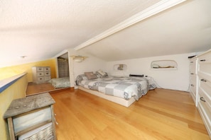 Ein Schlafzimmer mit Bett, Kommode und Nachttisch.