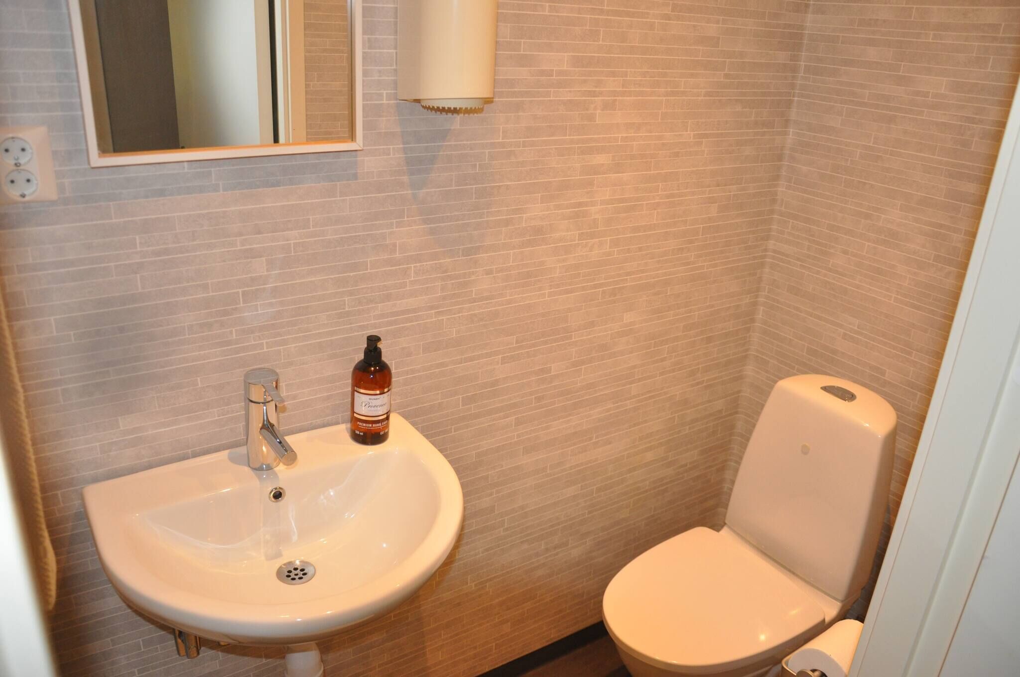 Une salle de bain avec un lavabo, des toilettes et un miroir.