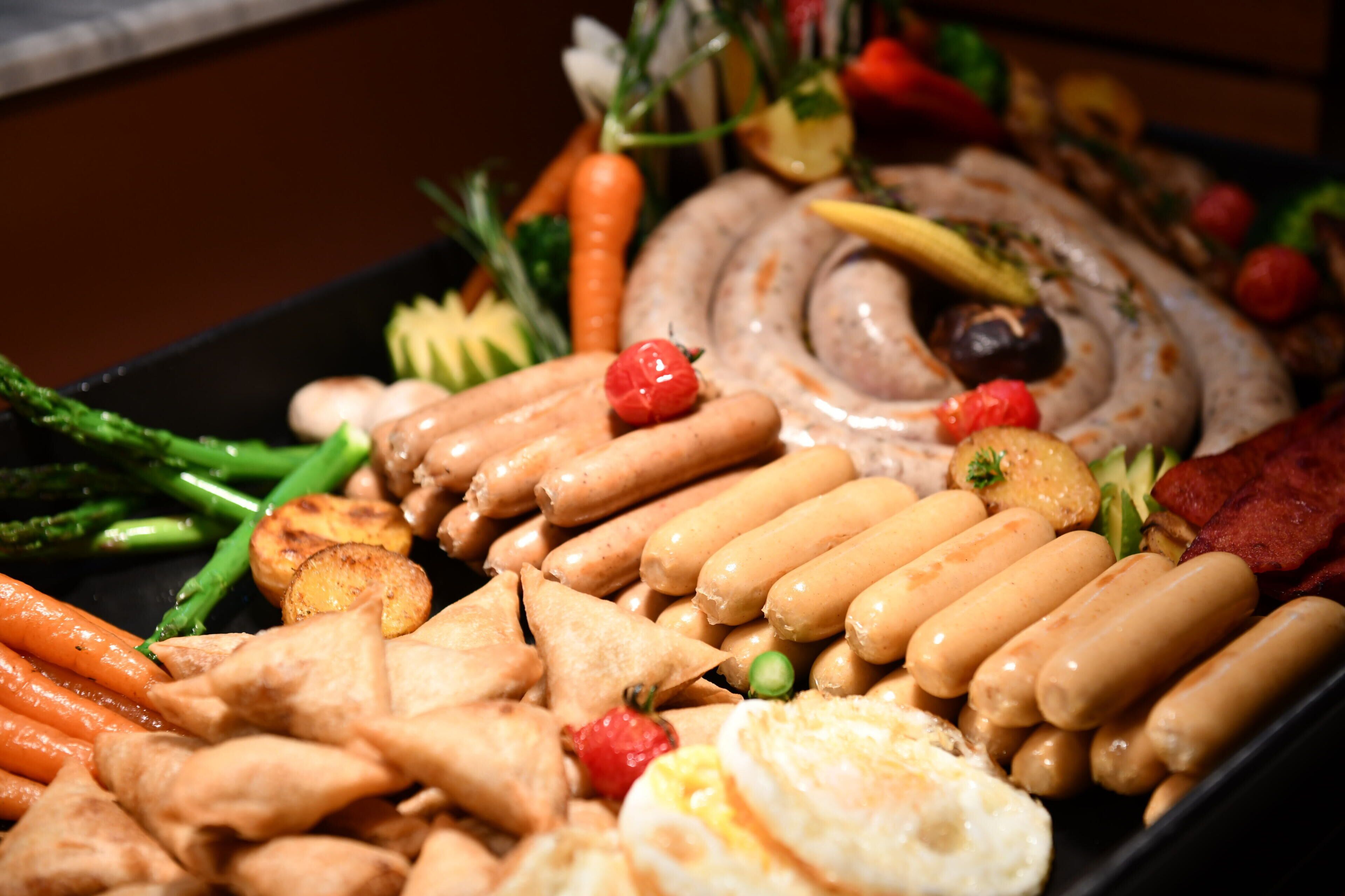 Une variété d’aliments, notamment des saucisses, des œufs et des légumes.