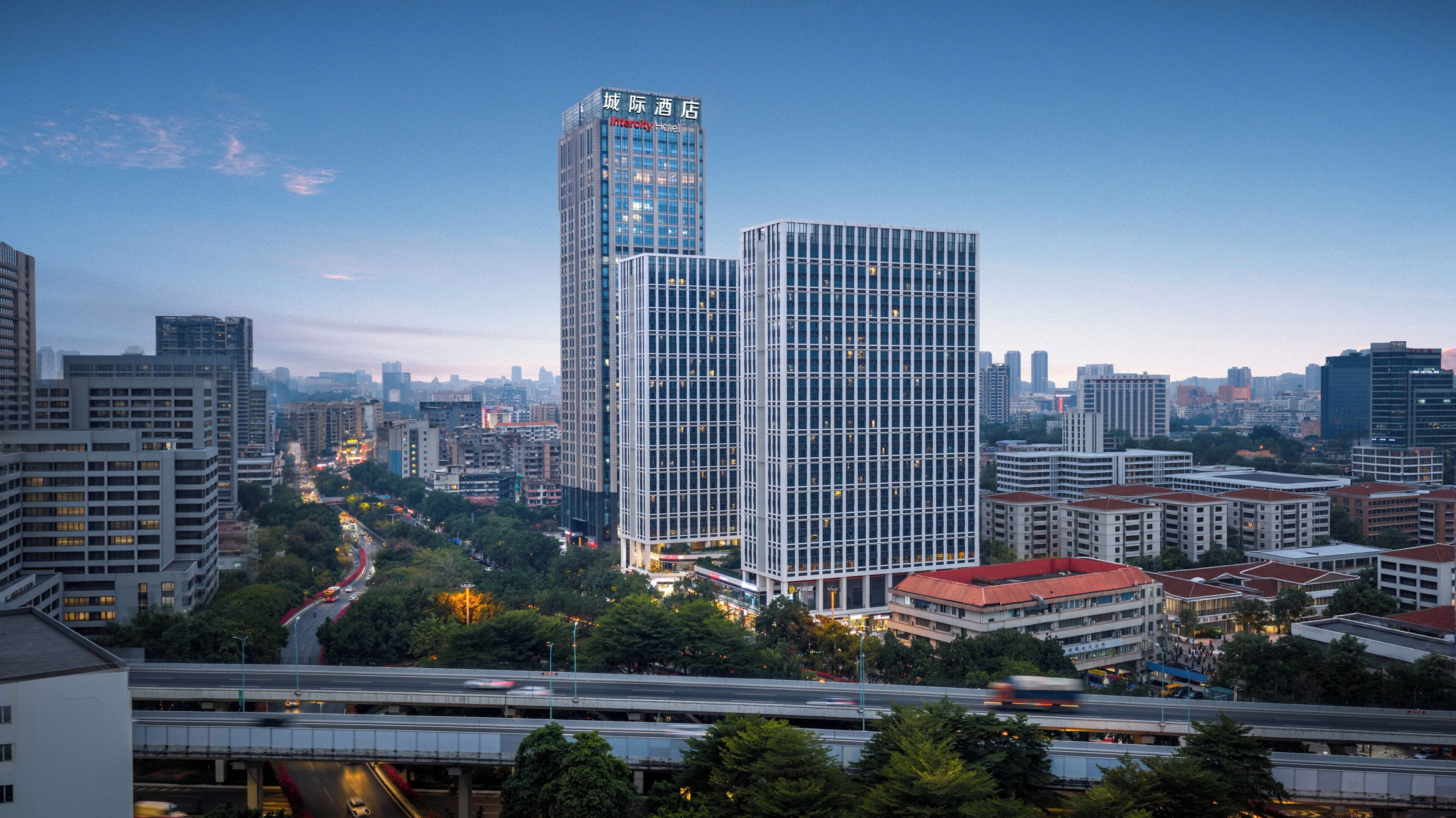 A cityscape with modern high-rise buildings, including a hotel with a prominent sign.