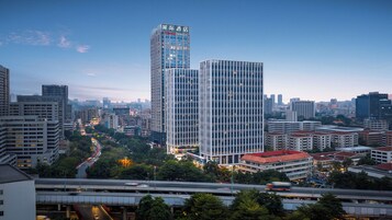Un paysage urbain avec des immeubles modernes de grande hauteur, dont un hôtel reconnaissable à son enseigne bien visible.