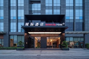 Une entrée d’hôtel moderne, avec une grande enseigne indiquant « Intercity Hotel ».