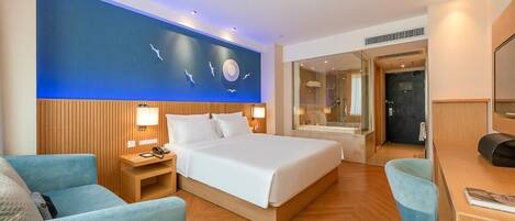 Une chambre d’hôtel moderne, dotée d’un grand lit, d’un bureau, d’une chaise, d’une table de chevet et d’un mur orné d’une fresque.