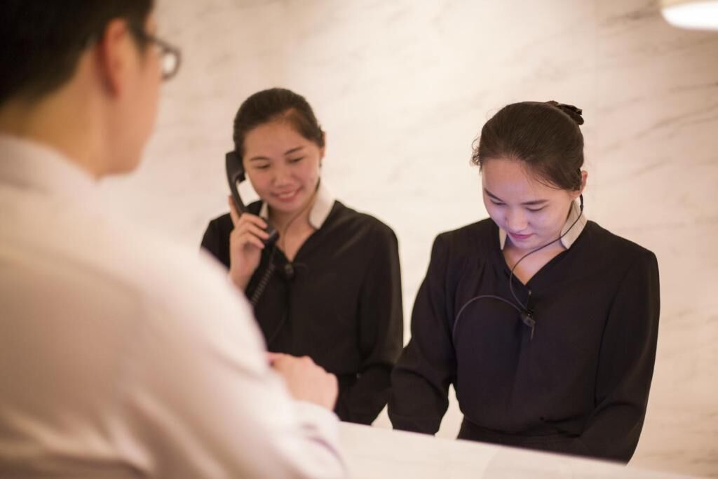 Ambiente profissional com pessoas em discussão, possivelmente em um contexto empresarial ou de atendimento.