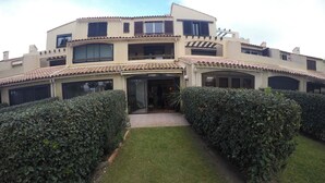A two-story building with a tiled roof, a central entrance, and a well-maintained lawn. - Beautiful apartment in a large wooded park (Saint-Cyprien)
