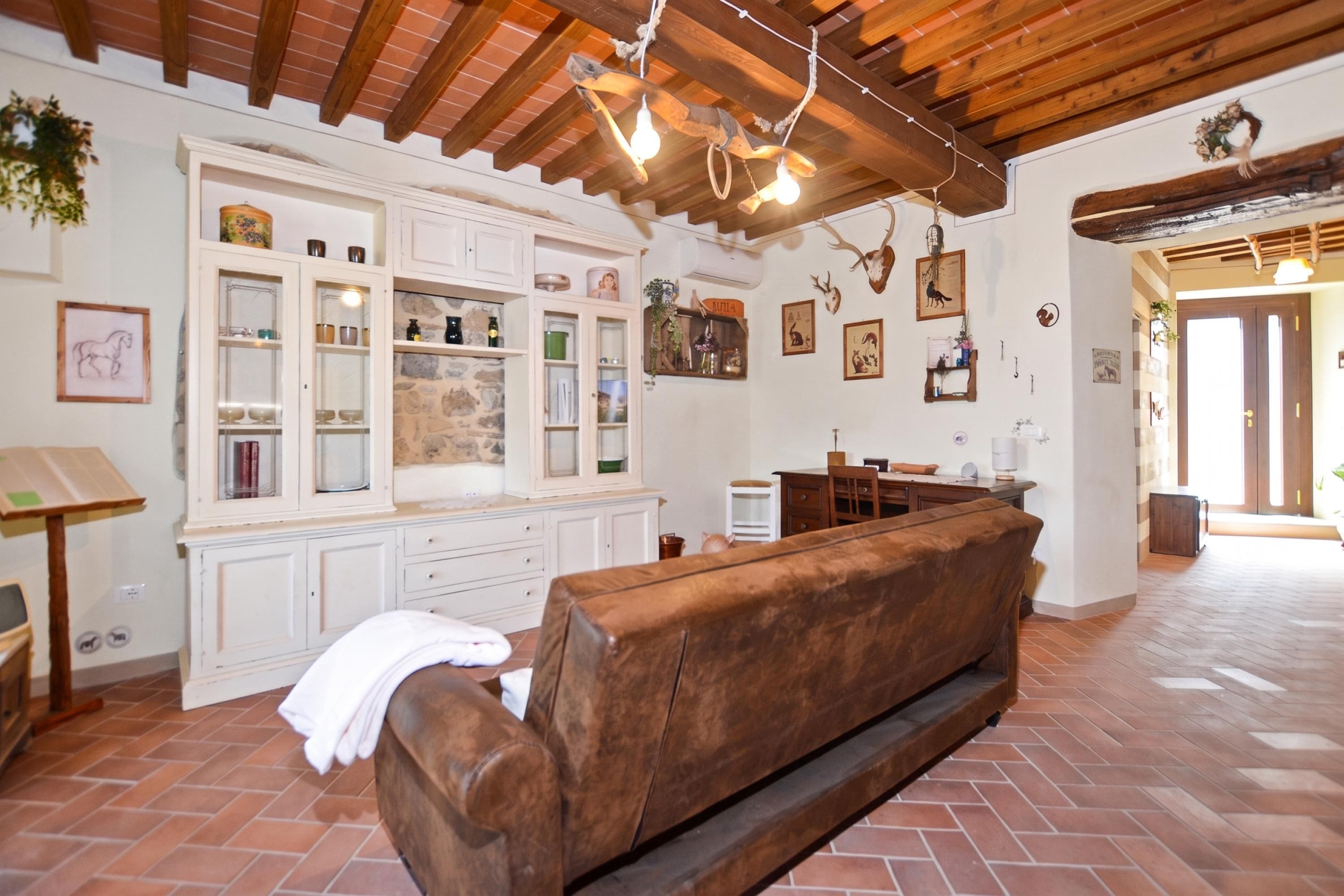 A rustic interior with a wooden bench, stone wall, and various decorative items.