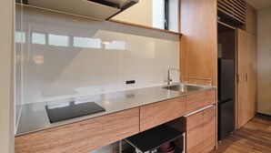 A modern kitchen with a stainless steel sink, wooden cabinets, and a built-in oven.