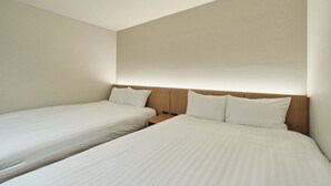 A hotel room with two single beds, wooden headboards, and a neutral color scheme.