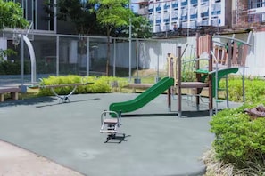A playground with a slide, swings, and climbing structures.