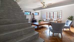 Eine Treppe führt zu einem Wohnbereich mit einer Couch, einem Couchtisch und einer Pflanze.