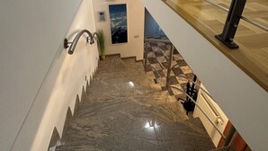 A staircase with a metal railing, a potted plant, and a fire extinguisher.