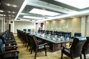 A conference room with a long table, multiple chairs, and a carpeted floor. - Tianbao Hotel (Fushun)