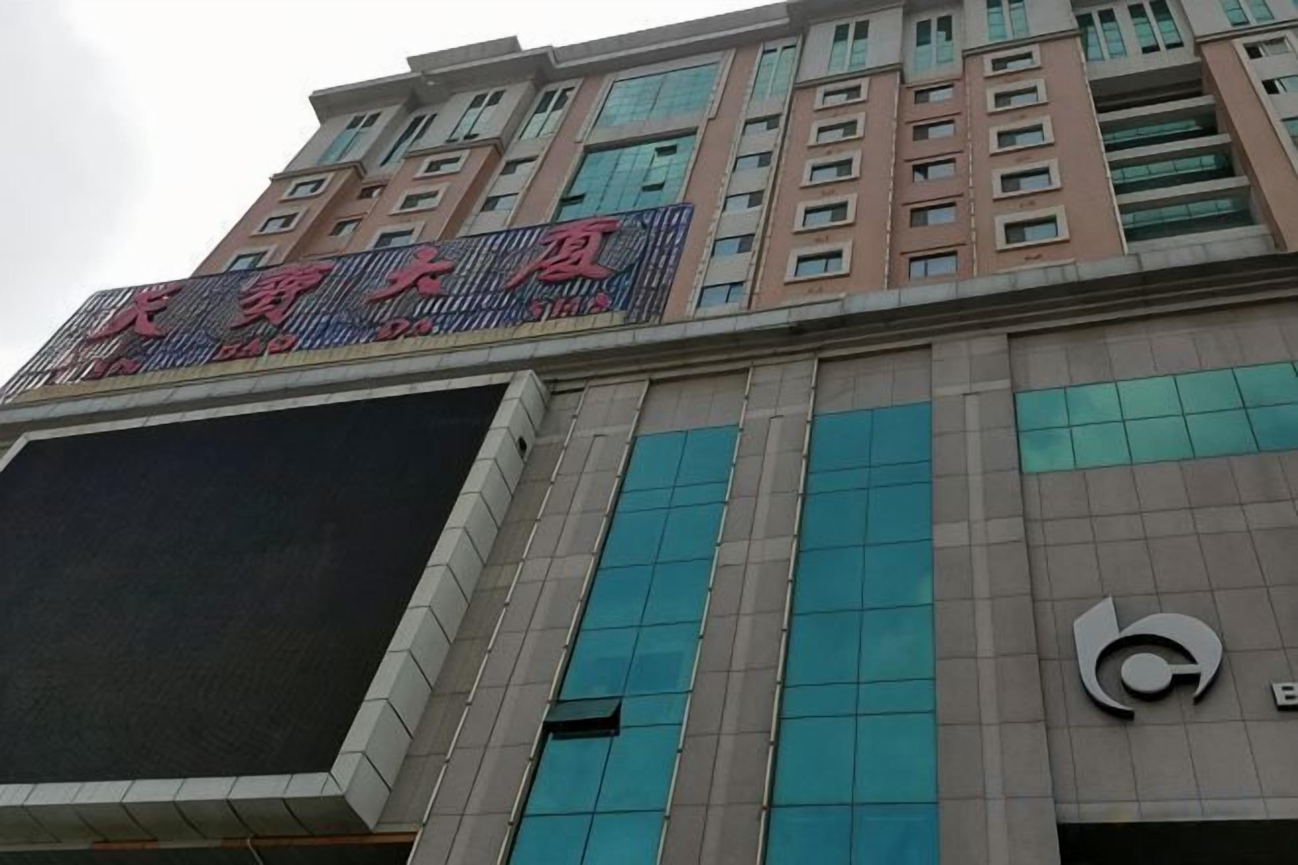 Un immeuble à plusieurs étages doté d’un grand écran numérique et d’une enseigne bien visible, avec des caractères chinois.