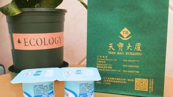 A potted plant labeled 'ECOLOGY' and a green brochure for Tian Bai Building.