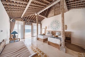 A bedroom with two beds, a large window, and a view of the sea. - Dolce Vita  (Penida Island)