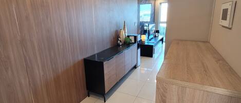 Un intérieur moderne avec un mur en bois, une console noire et un sol carrelé.