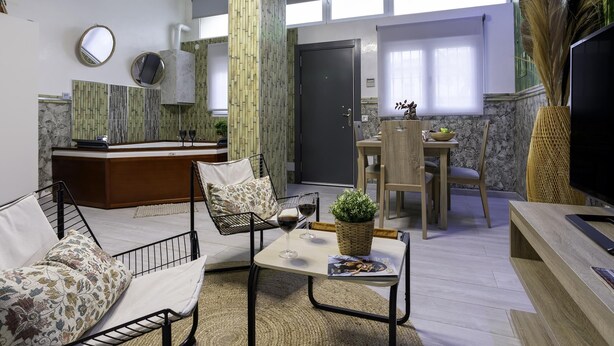 Una sala moderna con un sofá, una mesa de centro y un comedor con sillas y una mesa.
