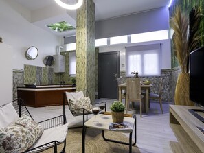 Uma sala de estar moderna com sofá, mesa de centro e área de jantar com cadeiras e mesa.