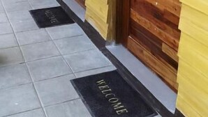 A hallway with wooden doors and a tiled floor.