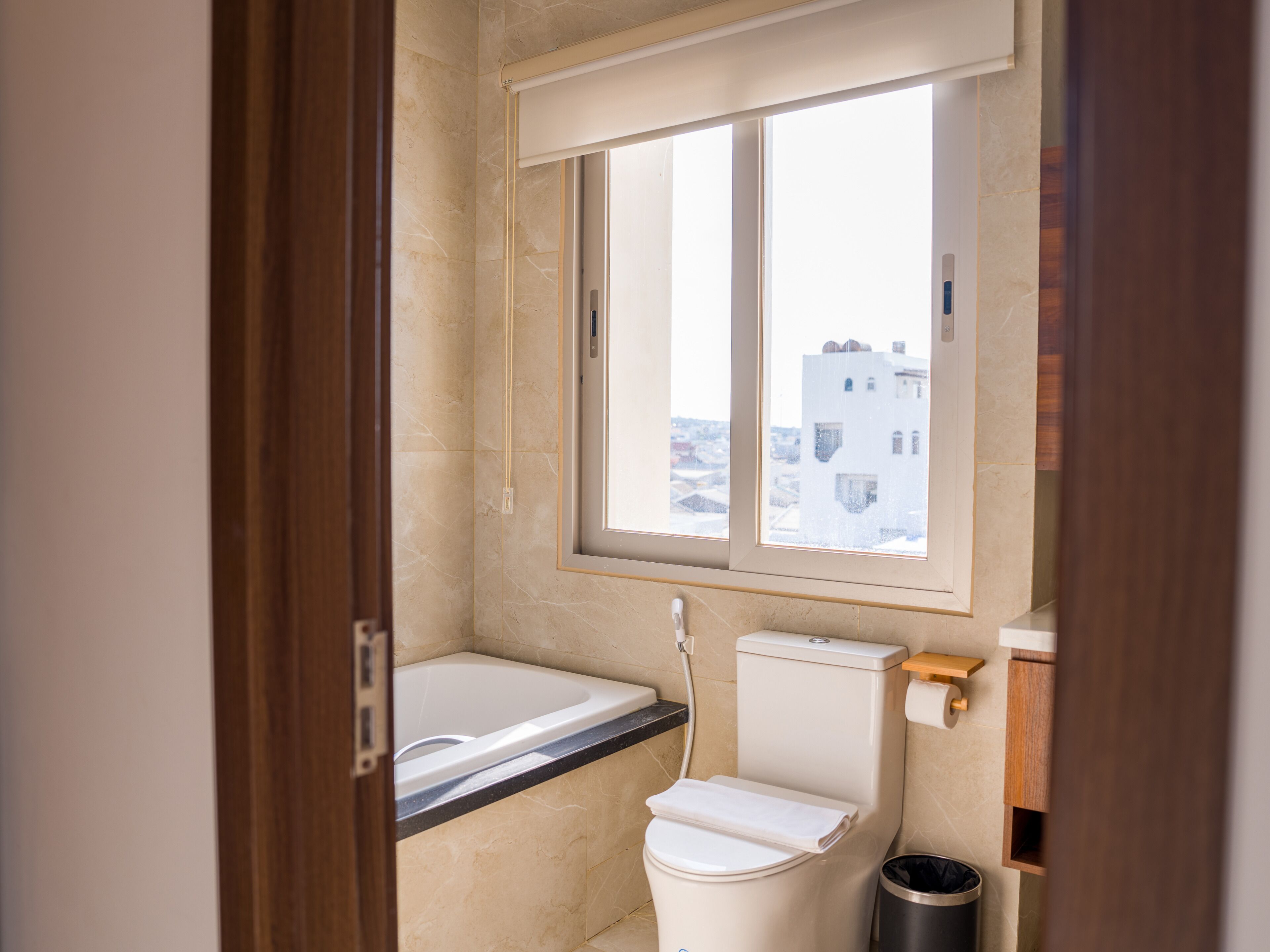 Un baño con bañera, inodoro y ventana.