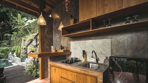 Una cocina moderna con armarios de madera, salpicadero de mármol y un lavamanos empotrado.