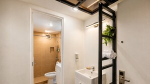 A modern bathroom with a toilet, sink, and shower. - V Saigon Suites by SMS Hospitality (Makati)
