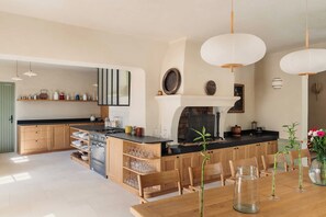 Een moderne keuken met houten kastjes, een centraal eiland en hanglampen.