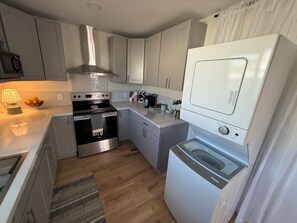 A compact kitchen with a built-in oven, a microwave, and a dishwasher. - FIFA 2026 Modern Luxury Stay-Minutes to SoFi (Inglewood)