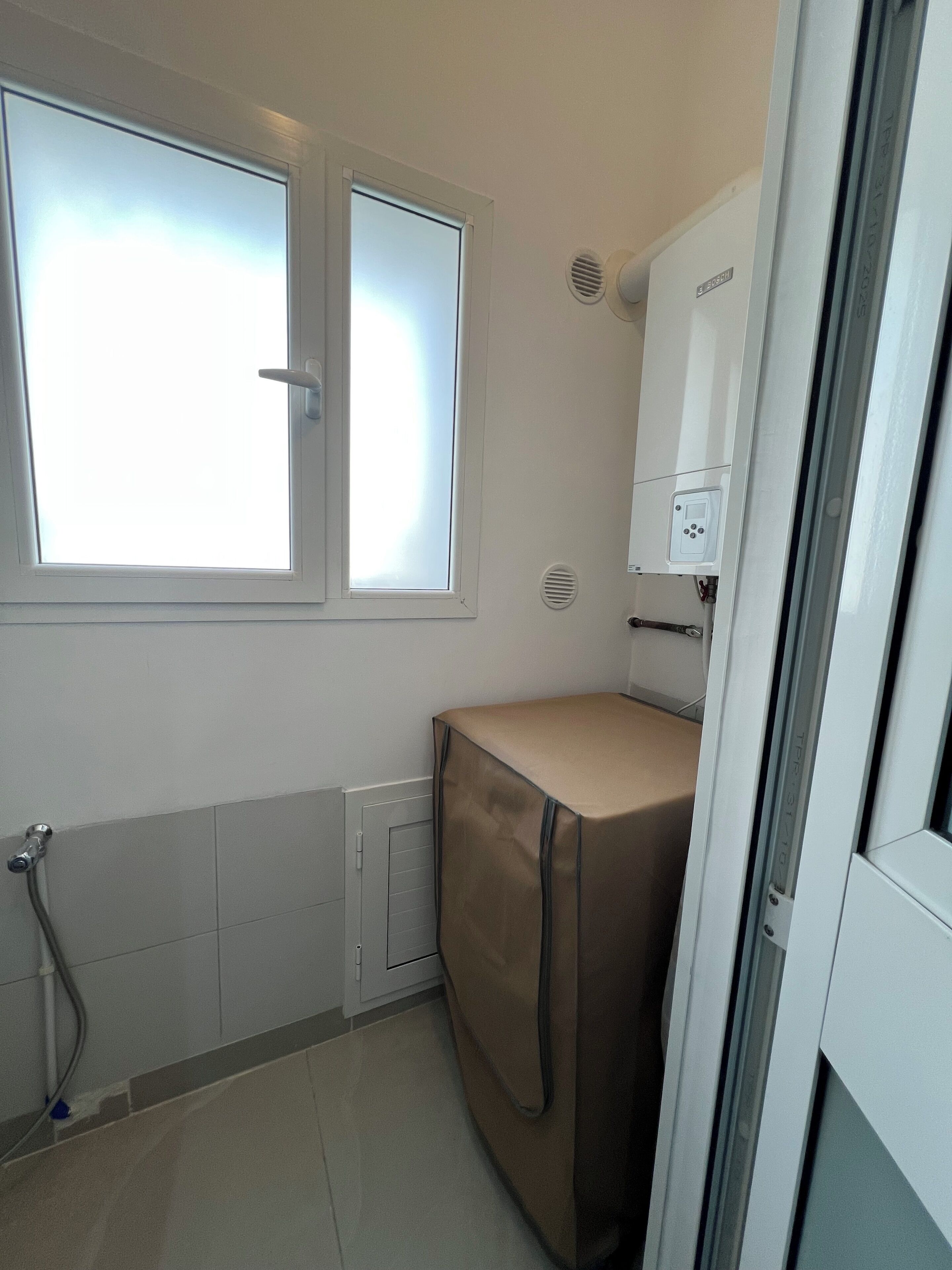 Ein kleines, separates Badezimmer mit Dusche, Toilette und Fenster.