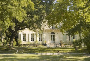 A building with a classical architectural style, surrounded by lush greenery and trees.