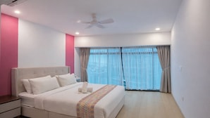 A modern bedroom with a bed, a ceiling fan, and a large window with curtains. - eaton (Kuala Lumpur)