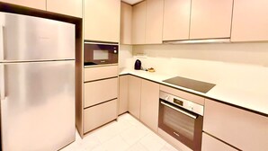 A modern kitchen with a refrigerator, microwave, oven, and dishwasher. - eaton (Kuala Lumpur)