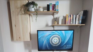 A modern workspace with a computer monitor, bookshelves, a small desk, and a chair. - Cosy studio at the foot of the ramparts (Boulogne-sur-Mer)