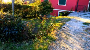 Un bâtiment rouge avec une allée gravillonnée et de la verdure tout autour.