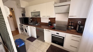 A modern kitchen with white cabinets, a stainless steel range, a built-in oven, a dishwasher, and a washing machine. - Apartment + Parking in Paris, Massy (TGV/RER B/C, Orly Bus) (Massy)