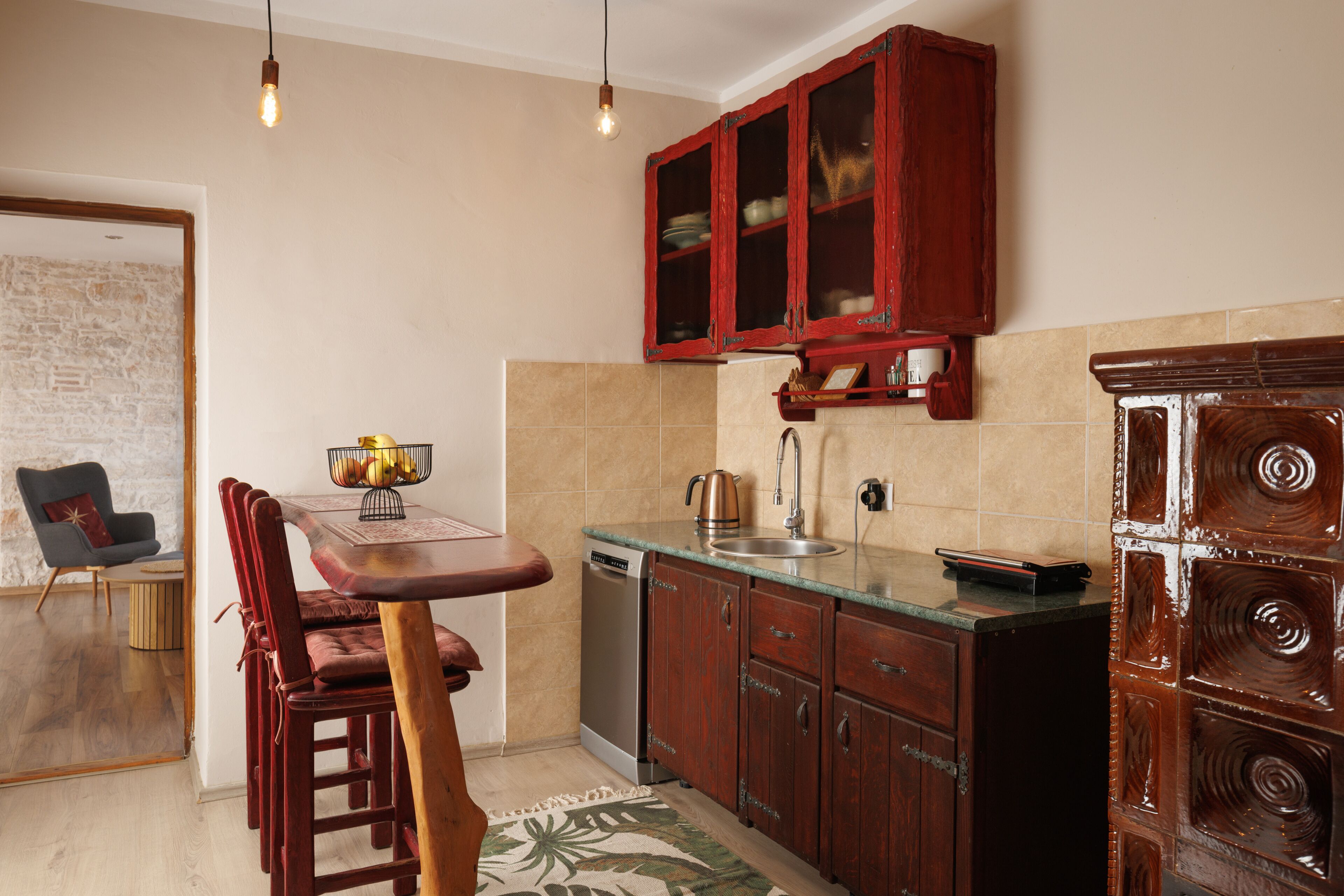 A kitchen with wooden cabinets, a dishwasher, and a dining area with a table and chairs.