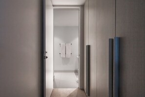 A hallway leading to a bathroom with a towel rack and a door. - Premium St Kilda Rd Apt Pool, Gym and Park Access (St Kilda)