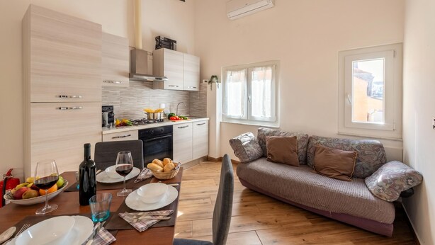 A modern kitchen with a dining area, a sofa, and a window. - Via Chiappori Sestri Ponente (Genoa)