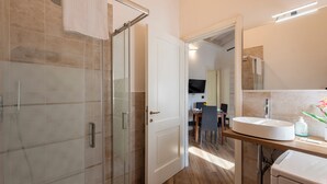 A modern bathroom with a glass shower enclosure, a white sink, and a mirror above it. - Via Chiappori Sestri Ponente (Genoa)