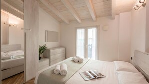A bedroom with a bed, a dresser, a mirror, and a window. - Via Chiappori Sestri Ponente (Genoa)