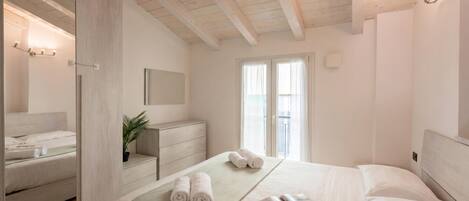 Un dormitorio con cama, cómoda, espejo y ventana.