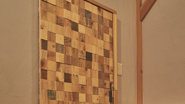 Ein traditioneller japanischer Raum mit Tatami-Boden, einer Holztür, die sich verschieben lässt, und einem kleinen Nachttisch mit Lampe.