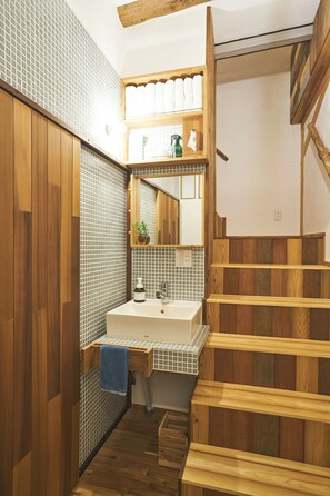 A bathroom with a wooden floor, a sink with a mirror, and a towel hanging on the wall. - 8 people OK / 1 building rental / 16 min. from Univa and Namba, 20 min. from Osaka Umeda / 4 min. from nearest station / Family groups welcome (大阪府大阪市此花区四貫島)