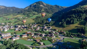 Uma aldeia com casas, estradas e montanhas ao fundo.