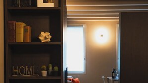 Un soggiorno moderno con libreria, divano, tavolo da pranzo e finestra.